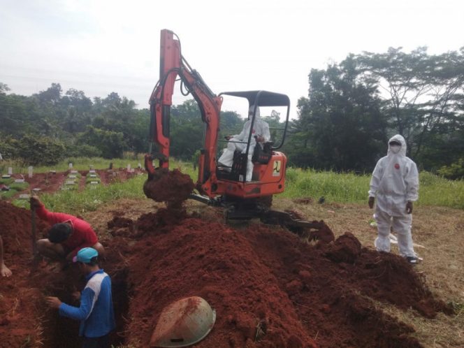 
					Satgas DPUPR membantu petugas gali kubur melakukan penggalian kubur menggunakan alat berat di TPU Karaba Tapos, Selasa (29/06/21). (Foto: istimewa).