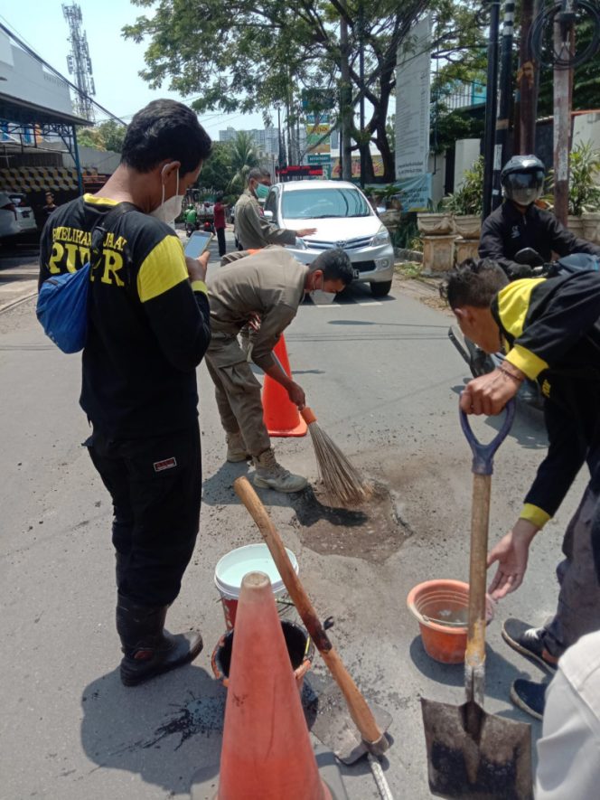 
					Satgas DPUPR Kota Depok saat menambal jalan berlubang di Jalan Bukit Cinere Raya, Kelurahan Gandul, Kecamatan Cinere, Selasa (12/10/21). (Foto: istimewa)