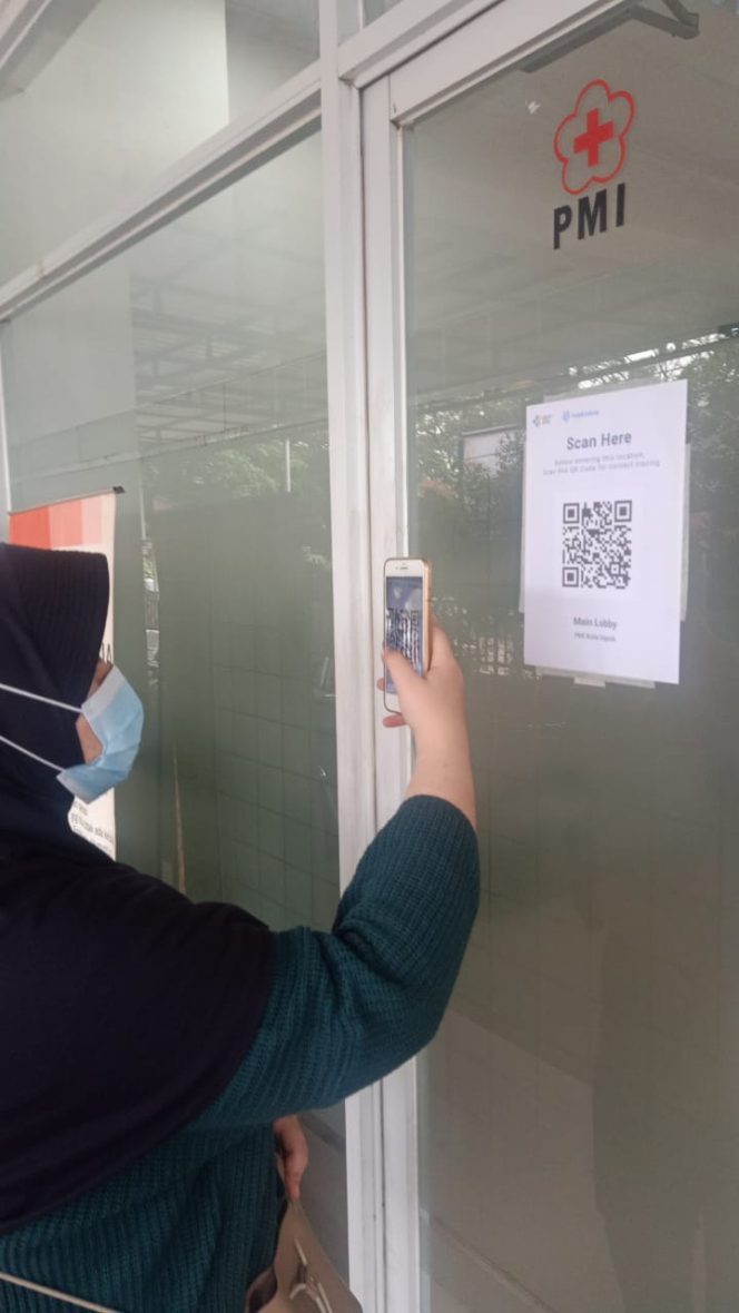 
					Salah satu pengunjung PMI melakukan scan barcode aplikasi PeduliLindungi di depan pintu masuk Markas PMI Kota Depok, Selasa (16/11/21). (Foto: istimewa)