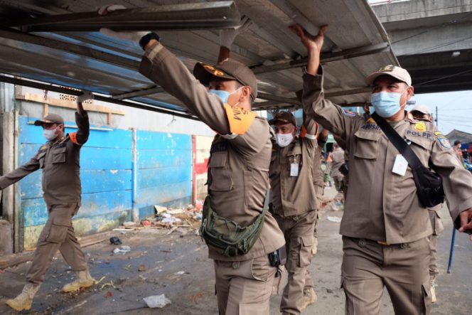 
					Personel Satpol PP Kota Depok saat melakukan penertiban bangunan pedagang di sisi barat bawah Jembatan Fly Over Arif Rahman Hakim (ARH). (Foto: JD01)