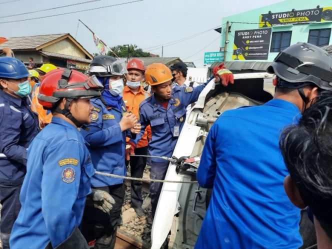 
					Petugas Damkar Depok saat mengevakuasi mobil yang terjepit di  perlintasan kereta di Jalan Raya Citayam, Gang Rawageni, Kelurahan Ratujaya, Kecamatan Cipayung, Rabu (20/04/22). (Foto : Istimewa).