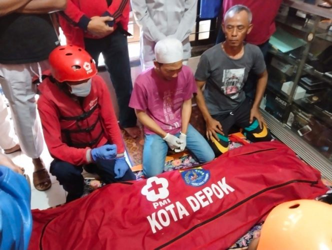 
					Relawan PMI Kota Depok bersama tim penyelamat lainnya saat mengevakuasi seorang anak yang terseret arus Sungai Ciliwung, Jumat (27/04/22). (Foto: istimewa)