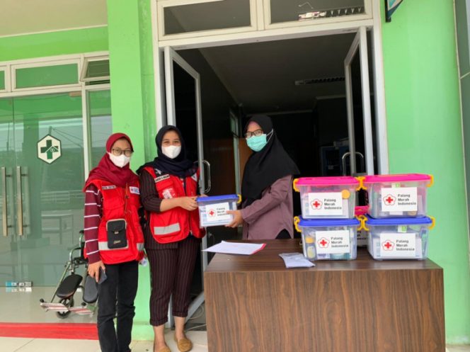 
					Relawan PMI Kota Depok memberikan paket isoman untuk warga melalui Puskesmas Jatijajar, Jumat (17/06/22). (Foto: dokumentasi PMI).