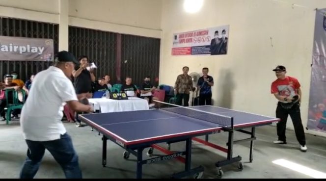 
					Laga pembuka Turnamen Tenis Meja Kelurahan Cup antara Kepala Seksi Pemerintahan, Ketentraman dan Ketertiban (Kasi Pemtrantib), Kecamatan Tapos, Tri Sutanto (kiri) bertanding melawan Lurah Jatijajar, Mujahidin (kanan), Sabtu (30/07/22). (Foto : Istimewa).