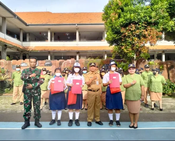 
					Foto: JD 05/Diskominfo Lurah Depok, Herman (tengah), Kepala SMP Mardi Yuana, Maria Yuliana Sulastri (paling kanan) bersama pelajar berprestasi yang meraih juara umum di masing-masing angkatan usai Upacara Bendera Merah Putih di halaman sekolah, Senin (6/2/2023).