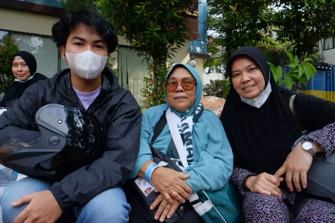 
					Suparni Suparman (tengah) dijemput keluarga saat kepulangan haji di Balai Kota Depok, Sabtu (08/07/23). Foto muadz