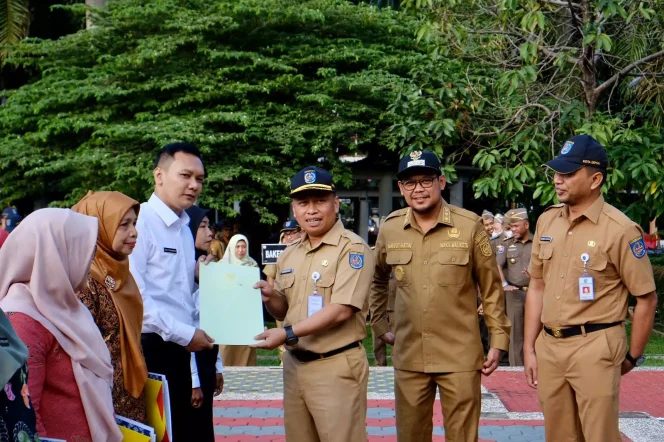 
					Sekda Kota Depok, Supian Suri bersama Wakil Wali Kota Depok, Imam Budi Hartono dan Kepala BKPSDM Kota Depok, Rahman Pujiarto menyerahkan SK Pengangkatan PPPK tenaga Guru kepada Wahyu Ramdani saat apel pagi, di lapangan Balai Kota Depok, Senin (03/07/23). (Foto: Diskominfo).