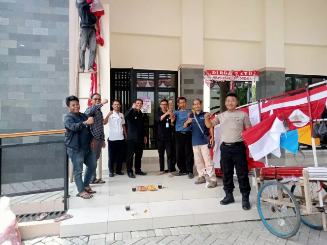 
					Lurah Boponter, Adi Supriadi bersama warga akan memasang dekorasi dan bendera merah putih di area kantor kelurahan, belum lama ini. (Foto: JD 05/Diskominfo).