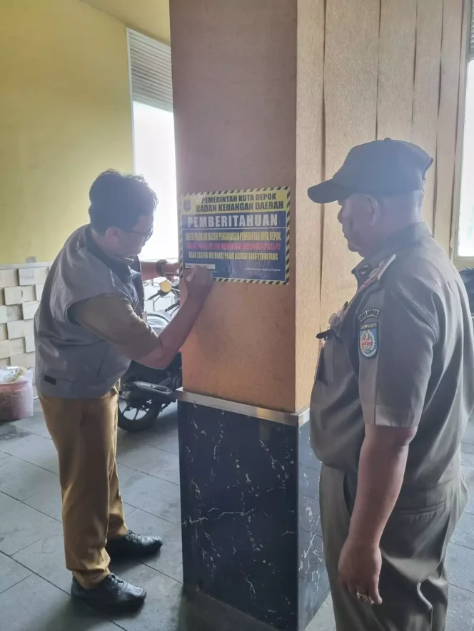 
					Petugas pungutan pajak dari BKD dan Satpol PP melakukan pemasangan stiker pada bangunan yang belum melunasi PBB-P2, di Jalan Margonda, Senin (04/09/23). (Foto dok. BKD Depok)