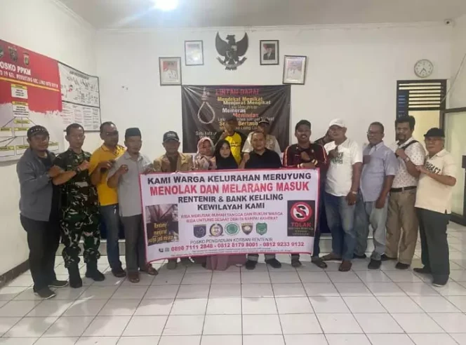 
					Lurah Meruyung, Asep Suherman saat foto bersama warga dengan spanduk menolak keberadaan bank keliling dan rentenir di wilayahnya. (Foto : Dokumentasi Lurah Meruyung)