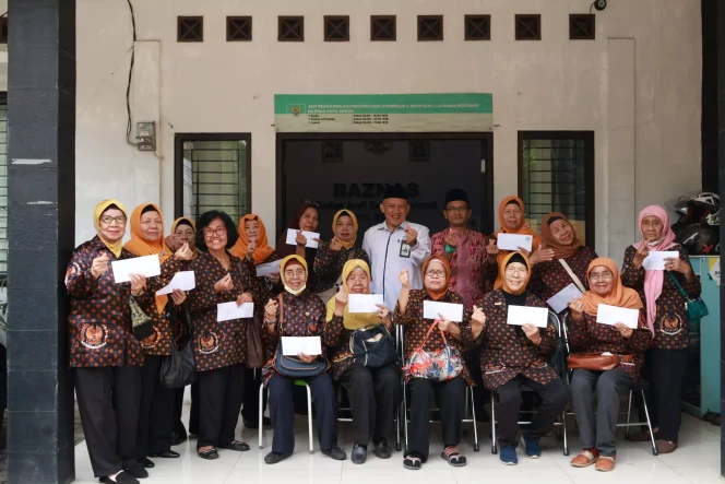 
					Ketua BAZNAS Depok, Endang Ahmad Yani (tengah, pakaian putih) bersama keluarga veteran yang mendapatkan bantuan. (Foto: Dokumentasi BAZNAS Depok)