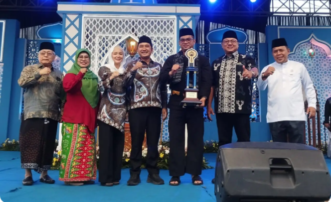 
					Camat Cipayung, M.Reza memegang Piala Bergilir kMTQH Kota Depok yang diserahkan oleh Wakil Wali Kota Depok, Chandra Rahmansyah, Kamis (13/11/25). (Foto: JD 01/Diskominfo)